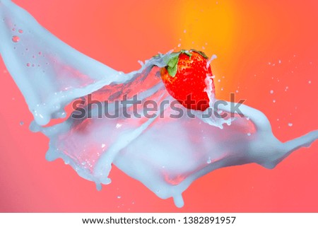 Food Photography. Milk Droplets Pouring Around Strawberry. Against Red Background.Horizontal Image Orientation