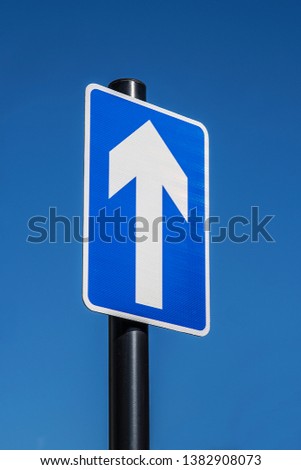 Plain blue and white 'ahead only' arrow road sign.