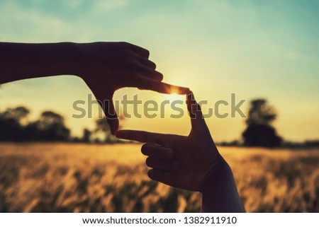 people make hand framing looking distant view sunrise. business concept 