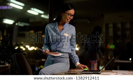 Smiling female architecture browsing website on laptop, creative profession
