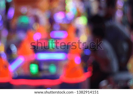 Beautiful defocused light in a game center in shopping mall. Colorful random decorating light in city. Blurred bokeh. 