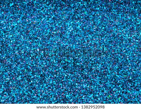 Background sequin. Blue background. Holiday abstract glitter background with blinking lights. Fabric sequins in bright colors. Fashion fabric glitter, sequins. Defocused. 