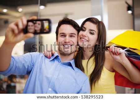 Happy couple taking a photo in the shopping mall