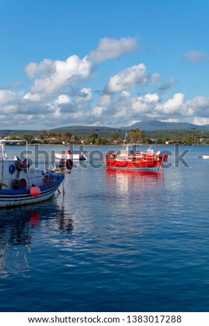 Seascape with sea harbor with clear blue water and traditional colorful greek fisher boats in sunny day