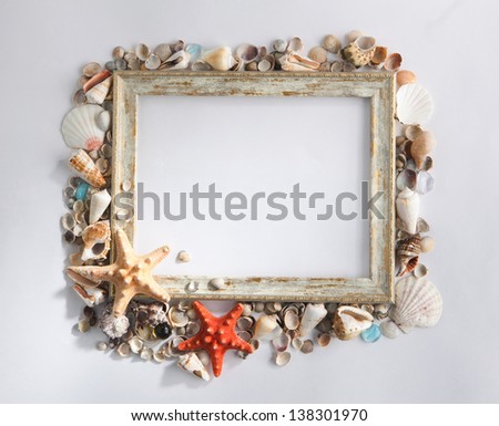 Shabby picture frame with blank space inside and shells on white background