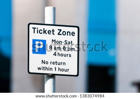 Street sign advising motorists that parking requires a ticket between certain hours.
