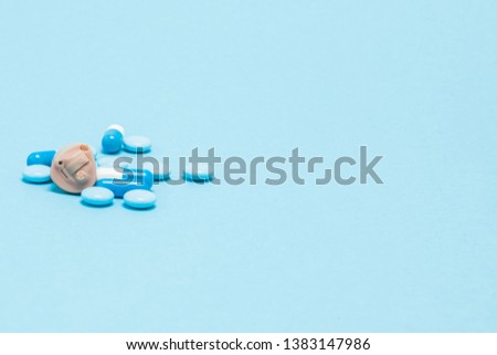 Hearing aid and blue pills on blue background. Medical, pharmacy and healthcare concept. Copy space. Empty place for text or logo.