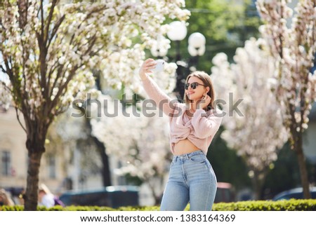 beautiful woman in sunglasses making selfie outdoors
