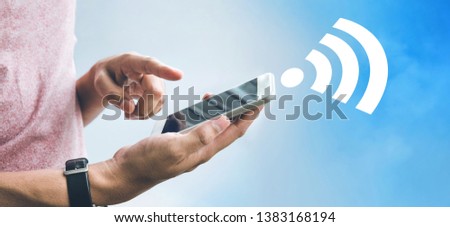 Internet wifi concepts with male hand holding smartphone,mobile and icon on sky background.panoramic images