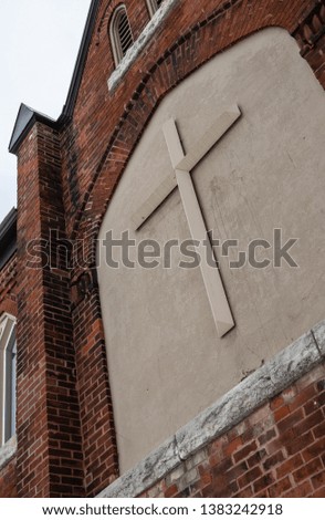 A cross on an exterior brick wall of an old Anglican Church in Ontario Canada.