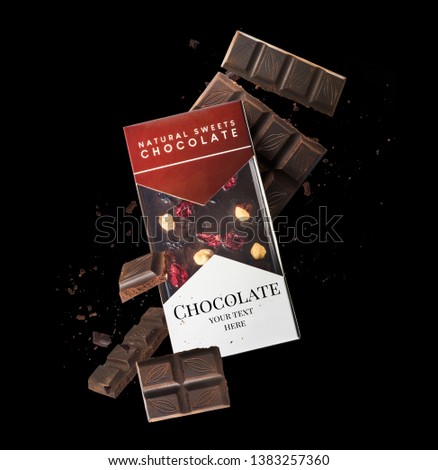 Flying in air tasty dark chocolate isolated on black background. High resolution close-up image