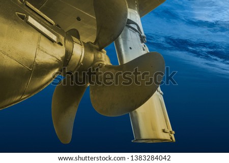 Golden propeller and rudder of big ship underway view. Close up image detail of ship. Transportation industry. Freight transportation. Ship repair, underwater survey and shipping business concept. Royalty-Free Stock Photo #1383284042