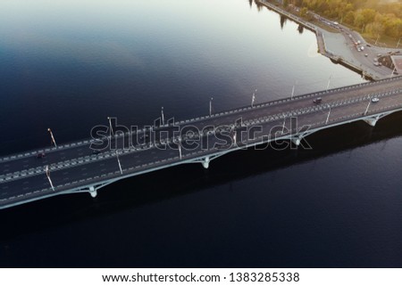 Aerial view of concrete bridge over river, car traffic on city bridge, transportation concept