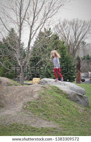Young girl standing on rock, enjoying spring