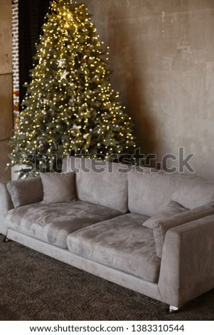 Stylish Christmas interior with a soft  sofa. Comfort home. Christmas tree with presents underneath in living room