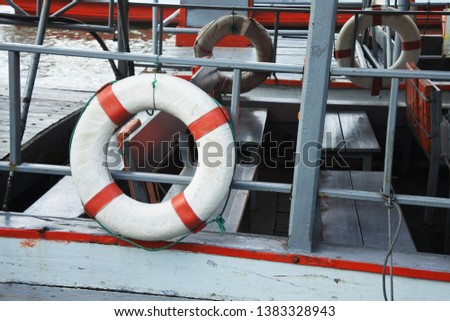 used grungy lifebuoy (or life guard) with rope and life vest with life belt on ferry service boat, for passenger life saving.