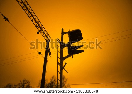 Moscow region / Railway traffic light dark silhouette, night time, long shutter. Orange cloudy sky, abandoned place background. Industrial outdoor landscape. Unused old railway line, nobody around