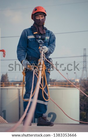 Focus male worker using rope access of inspection storage tank