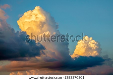 Cumulus and shadowy stratocumulus clouds near sunset on a summer evening, for motifs of weather, development, transition