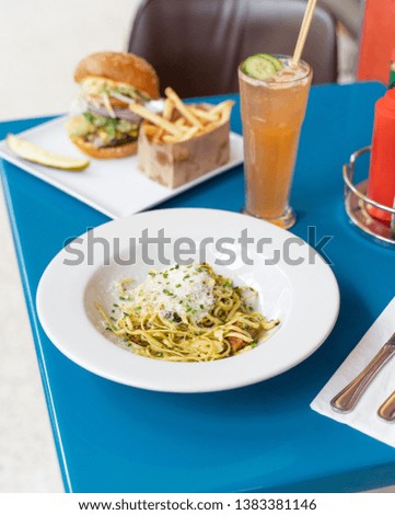 Stock photo of pesto pasta Alfredo. A gluten filled but delicious dish made with spaghetti and topped with aged parmesan cheese.