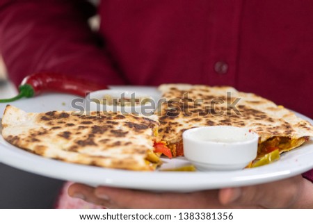 A serviced quesadilla with sauces deliciously taste