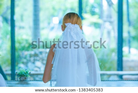 Bridal veil The bride wearing a white wedding dress beautiful looking out the window in a day of joy