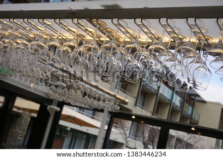 Rows of glasses rack hang upside down inside bar drinking party 