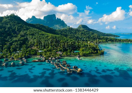 Bora Bora aerial drone video of travel vacation paradise with overwater bungalows luxury resort, coral reef lagoon ocean beach. Mount Otemanu, Bora Bora, French Polynesia, Tahiti, South Pacific Ocean Royalty-Free Stock Photo #1383446429
