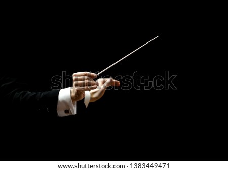 Hands of conductor on a black background Royalty-Free Stock Photo #1383449471