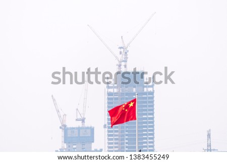 Flags fly in front of a building being built in chengdu.