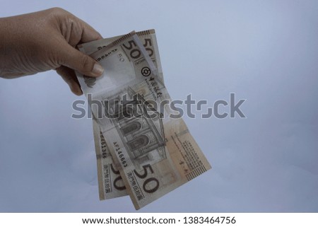Hand holding MOP Macao bank notes