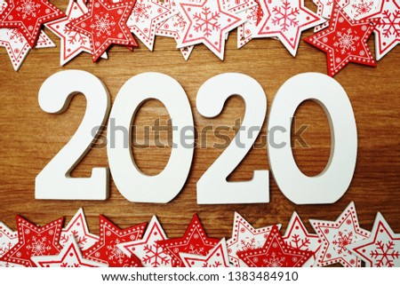 2020 happy new year with white and red star ornament decoration on wooden background