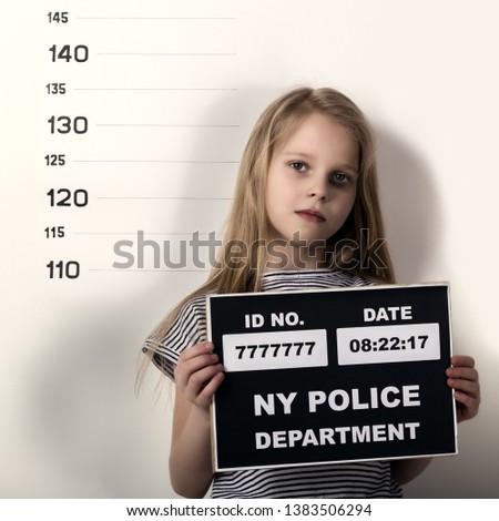 Young beautiful blonde child with a sign, Criminal Mug Shots. difficult children, social tension