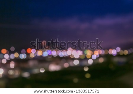 Blurred picture with bokeh light along the horizon line with blue and violet night background.