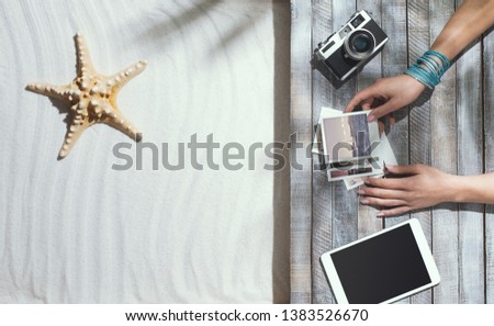 Woman lying on the beach and watching photos of her summer vacations, blank copy space