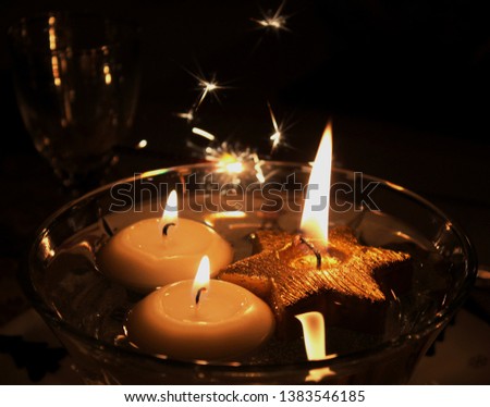 Candles in water pond, sparks in the darkness