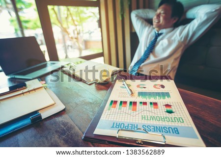 Exhausted tired businessman working on laptop at office but still smiling. Stress or failure concept. Angry and tired businessman crumpling papers in the office.