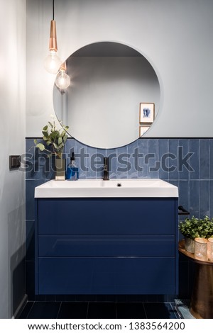 Designed bathroom with stylish blue cabinet and blue wall tiles Royalty-Free Stock Photo #1383564200