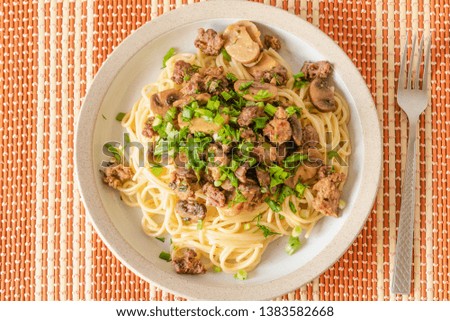 Spaghetti with homemade sausage and mushroom stew on a plate - traditional Italian pasta with Boscaiola mushroom sauce.