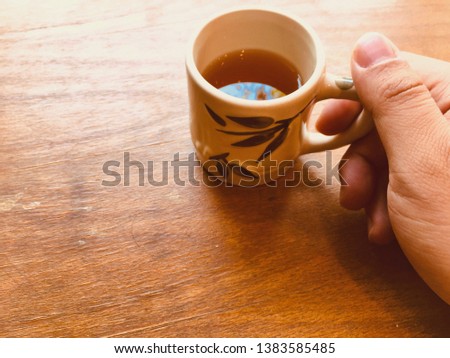 Cup of tea in the hand of men. on a wooden background. with copy space.