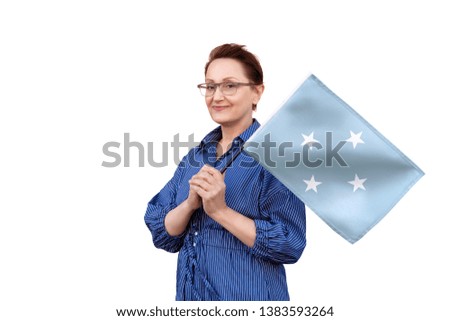 Micronesia flag. Woman holding Micronesia flag. Nice portrait of middle aged lady 40 50 years old holding a large flag isolated on white background.
