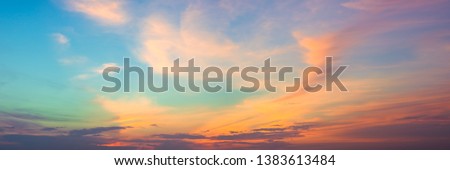 Panoramic beautiful colorful golden hour twilight sky. Beautiful cloud and sky nature background in magic hour. Amazing colorful sky and dramatic sunset evening sky. Royalty-Free Stock Photo #1383613484