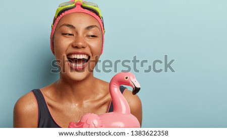 Sport, recreation, swimming concept. Smiling joyful lady spends summer holidays actively, enjoys favourite hobby, leads healthy lifestyle, holds inflatable float rubber ring, has active rest.