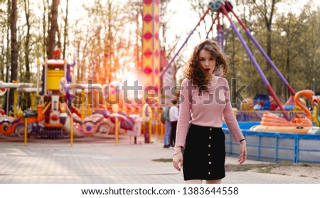 Beautiful exited smiling woman having fun and dancing at amusement park at hot summer