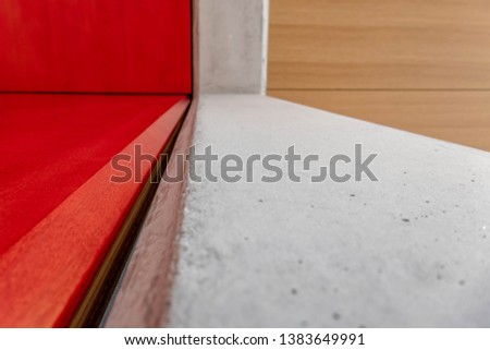 red and brown lacquered wood and raw cement surface close up background