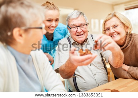 Group of seniors with dementia playing with a wooden puzzle in nursing home or at home