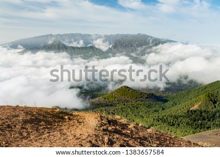 Tradewind clouds moving against the mountains of La Palma between the Caldera de Taburiente in the background and Cumbre Vieja. Seen from the top of the volcano Birigoyo in the evening.
