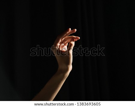 Female hands on a dark background in a photo studio photographed at high resolution