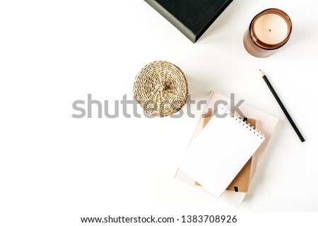 Neutral minimal office desk workspace with notebook on white background. Flat lay, top view.