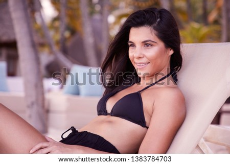 Beautiful brunette relaxing on sun lounger